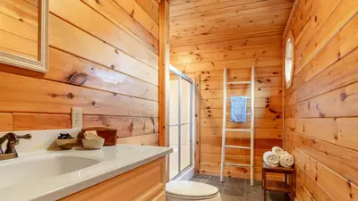 a bathroom with a white sink and wooden walls at Secluded w Deck Views Hot Tub Ping Pong Hudson in the Berks by AvantStay in East Chatham