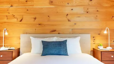 a bedroom with a white bed with wooden walls at Secluded w Deck Views Hot Tub Ping Pong Hudson in the Berks by AvantStay in East Chatham