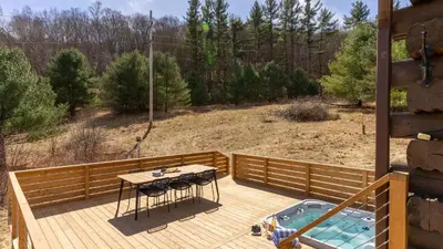 a wooden deck with a table and a pool at Secluded w Deck Views Hot Tub Ping Pong Hudson in the Berks by AvantStay in East Chatham