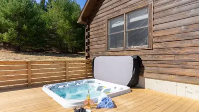 a hot tub sitting on a deck next to a house at Secluded w Deck Views Hot Tub Ping Pong Hudson in the Berks by AvantStay in East Chatham