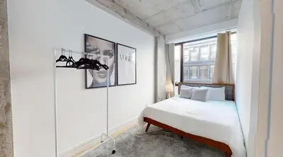 a white bedroom with a bed and a window at Sleek Two Bedroom in Manhattan in New York
