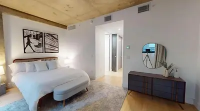 a bedroom with a large bed and a mirror at Sleek Two Bedroom in Manhattan in New York