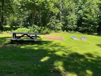 a picnic table and two chairs in the grass at The A-Frame at Harvest Moon Acres in Stamford