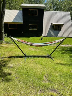 a hammock in the grass in front of a house at The A-Frame at Harvest Moon Acres in Stamford