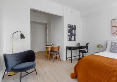 a bedroom with a bed and a desk and chairs at Awesome Sunny Studio! Best Location! in New York