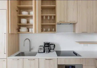 a kitchen with wooden cabinets and a sink at Awesome Sunny Studio! Best Location! in New York