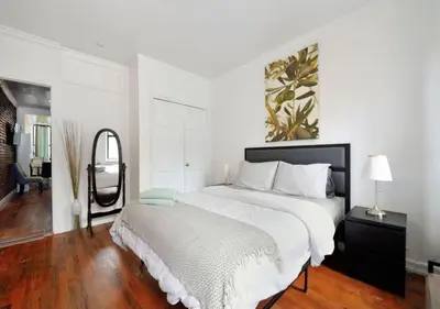 a white bedroom with a large bed and a mirror at Furnished 2 Bedroom Apartment Midtown West NYC, June To Aug 90 Days Stay Required in New York