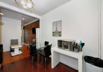 a living room with a table with chairs and a microwave at Furnished 2 Bedroom Apartment Midtown West NYC, June To Aug 90 Days Stay Required in New York