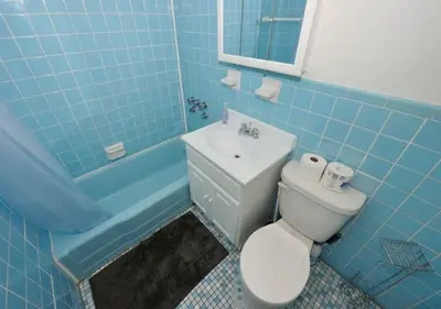 a blue bathroom with a toilet and a sink at Charming UES Studio, Walk to Subway & Central Park, June To Aug 90 Days Stay Required in New York