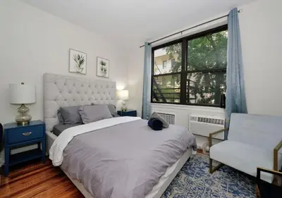a bedroom with a bed and a chair and a window at Charming UES Studio, Walk to Subway & Central Park, June To Aug 90 Days Stay Required in New York