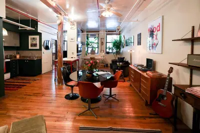 a living room with a table and guitars in it at Artistic Vintage Loft in Williamsburg in Brooklyn