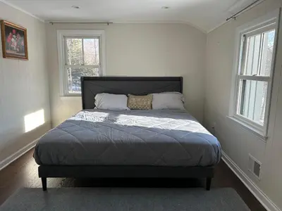 a bed in a room with two windows at Room in Lake Home - 2BR 1BA Kitchenette in Greenwich