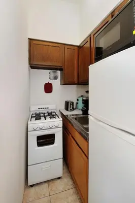 a kitchen with a white stove and a refrigerator at Amazing Upper East Side Studio! Epic Location!, June To Aug 90 Days Stay Required in New York