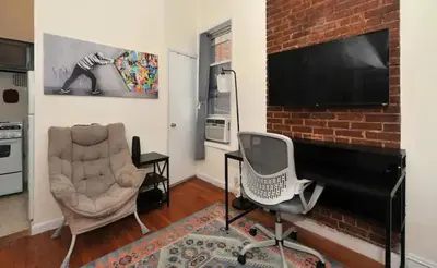 a living room with two chairs and a flat screen tv at Amazing Upper East Side Studio! Epic Location!, June To Aug 90 Days Stay Required in New York