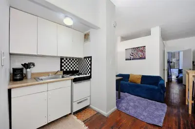 a kitchen with a sink and a blue couch in a room at Furnished Apartment Room Rental In NYC, June To Aug 90 Days Stay Required in New York