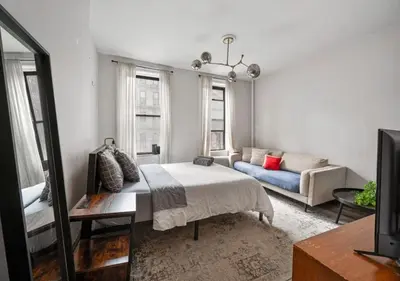 a living room with a bed and a couch at Prime Murray Hill 2 BR Gem, June To Aug 90 Days Stay Required in New York