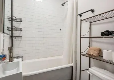 a white bathroom with a tub and a sink at Prime Murray Hill 2 BR Gem, June To Aug 90 Days Stay Required in New York