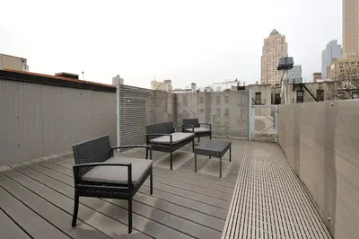 a balcony with chairs and tables on a building at Spacious 2BR 2BA with Rooftop Walk to Times Square, June To Aug 90 Days Stay Required in New York