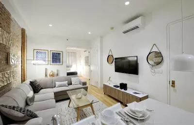 a living room with a couch and a table at Spacious 2BR 2BA with Rooftop Walk to Times Square, June To Aug 90 Days Stay Required in New York