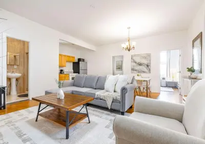a living room with a couch and a table at Prime Location Upper Manhattan Furnished Apartment, June To Aug 90 Days Stay Required in New York