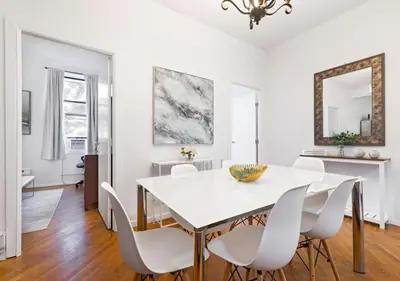 a white dining room with a white table and chairs at Prime Location Upper Manhattan Furnished Apartment, June To Aug 90 Days Stay Required in New York