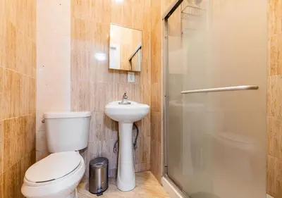 a bathroom with a toilet and a sink and a shower at Prime Location Upper Manhattan Furnished Apartment, June To Aug 90 Days Stay Required in New York