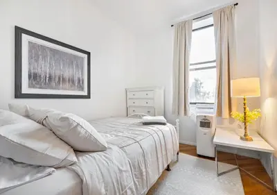 a white bedroom with a bed and a window at Prime Location Upper Manhattan Furnished Apartment, June To Aug 90 Days Stay Required in New York