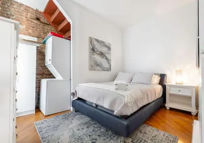 a bedroom with a bed and a brick wall at Prime Location Upper Manhattan Furnished Apartment, June To Aug 90 Days Stay Required in New York