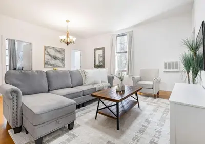 a living room with a couch and a table at Prime Location Upper Manhattan Furnished Apartment, June To Aug 90 Days Stay Required in New York