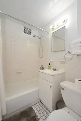 a white bathroom with a tub and a toilet and a sink at Prime Location Murray Hill! Grand Central Station!, June To Aug 90 Days Stay Required in New York