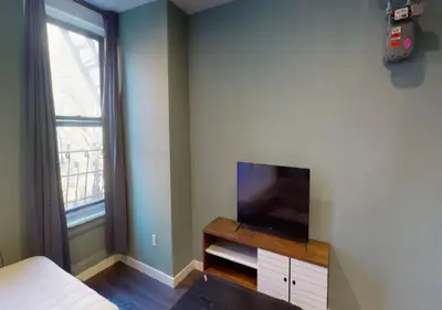 a bedroom with a flat screen tv and a bed at Amazing Studio in Kips Bay! in New York