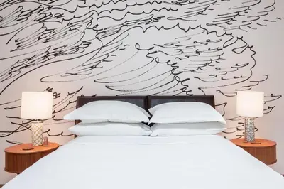 a bedroom with a white bed with wings on the wall at Roedonis SoHo in New York
