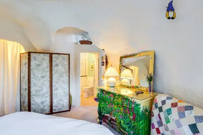 a bedroom with a bed and a dresser with a mirror at Less Than 6 Mi to Arlington Whimsical Stone Abode! in Sandgate