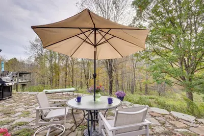 a table with an umbrella on a patio at Less Than 6 Mi to Arlington Whimsical Stone Abode! in Sandgate