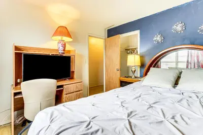 a bedroom with a bed and a desk and a tv at 3 Mi to Dtwn New Haven Colorful Condo with Yard! in West Haven
