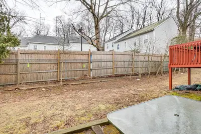 a backyard with a wooden fence and a skateboard ramp at 3 Mi to Dtwn New Haven Colorful Condo with Yard! in West Haven