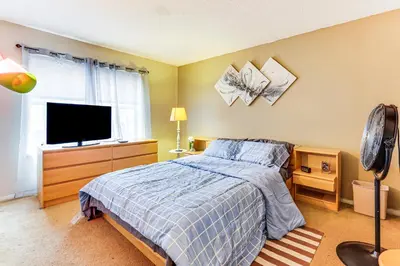 a bedroom with a bed and a flat screen tv at 3 Mi to Dtwn New Haven Colorful Condo with Yard! in West Haven