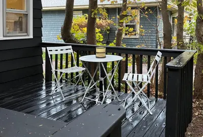two chairs and a table on a deck with a candle at Phoenicia Bungalow in Phoenicia