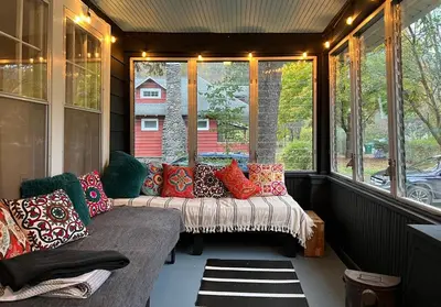 a screened in porch with a couch in front of a window at Phoenicia Bungalow in Phoenicia