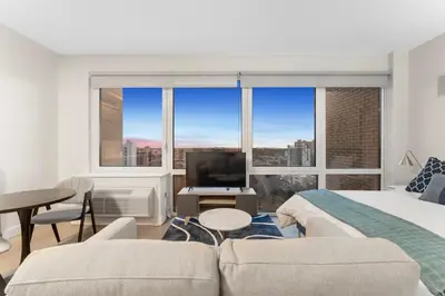a bedroom with a bed and a large window at Queens Studio Jewel Luxury and Comfort Combined in Mary Immaculate Hospital Heliport