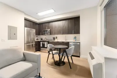 a kitchen with a table and chairs and a couch at Queens Studio Jewel Luxury and Comfort Combined in Mary Immaculate Hospital Heliport