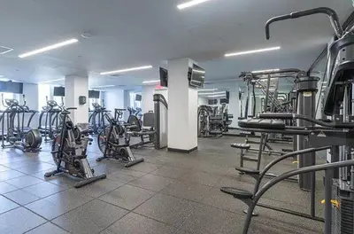 a gym with several treadmills and exercise bikes at Queens Studio Jewel Luxury and Comfort Combined in Mary Immaculate Hospital Heliport