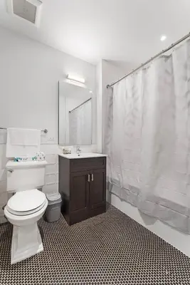 a bathroom with a toilet and a sink and a mirror at Queens Studio Jewel Luxury and Comfort Combined in Mary Immaculate Hospital Heliport
