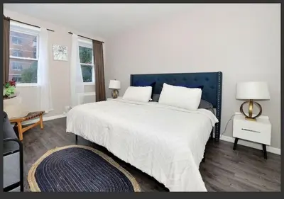 a white bedroom with a large bed with a blue headboard at Four Bedroom Prime Furnished Rental, June To Aug 90 Days Stay Required in New York