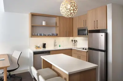 a kitchen with wooden cabinets and a stainless steel refrigerator at Element Lenox Berkshires in Lenox