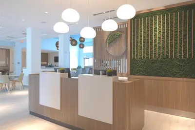 an office lobby with a green accent wall and pendant lights at Element Lenox Berkshires in Lenox