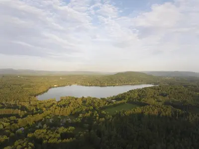an aerial view of a lake in the middle of a forest at Element Lenox Berkshires in Lenox