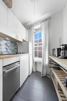 a kitchen with white cabinets and a window at Best Location in Greenwich Village in New York