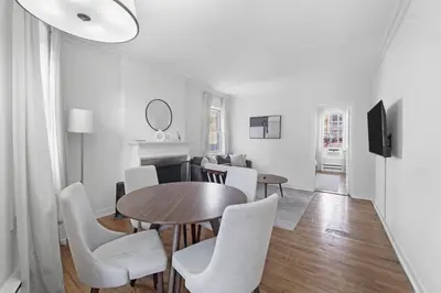 a dining room with a table and white chairs at Best Location in Greenwich Village in New York