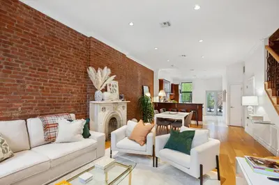 a living room with white furniture and a brick wall at Luxury Oasis in Manhattan in New York